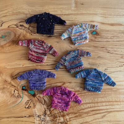 six tiny handknitted sweater ornaments