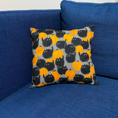 a pillow with fabric showing cats and pumpkins