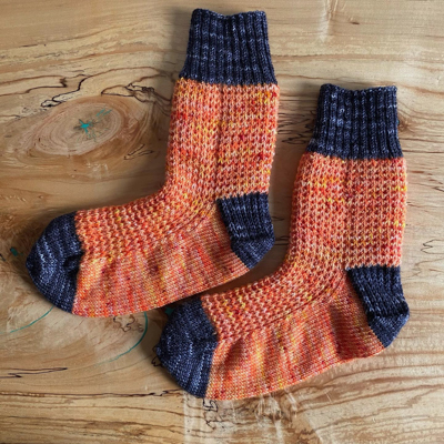 a pair of orange halloweeny socks with dark grey cuffs, heels, and toes
