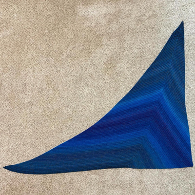 a triangular knitted shawl made from a handspun gradient