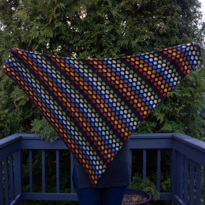 a triangular shawl with colorful honeycomb stripes