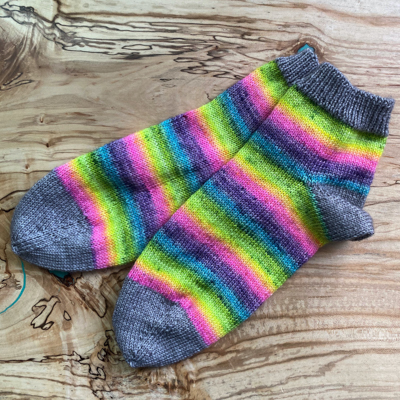 a pair of rainbow striped handknit socks